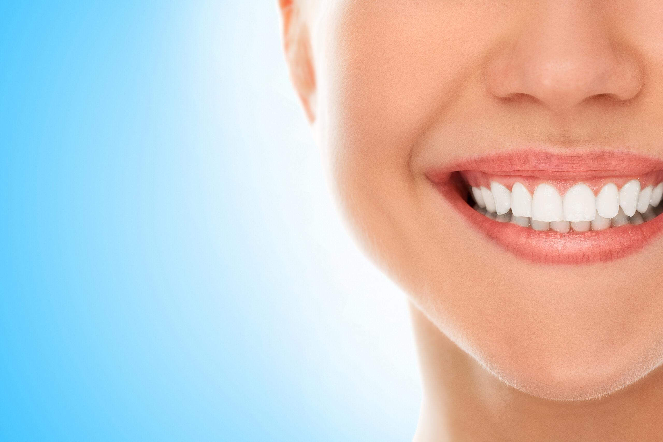 A woman is smiling while being at the dentist